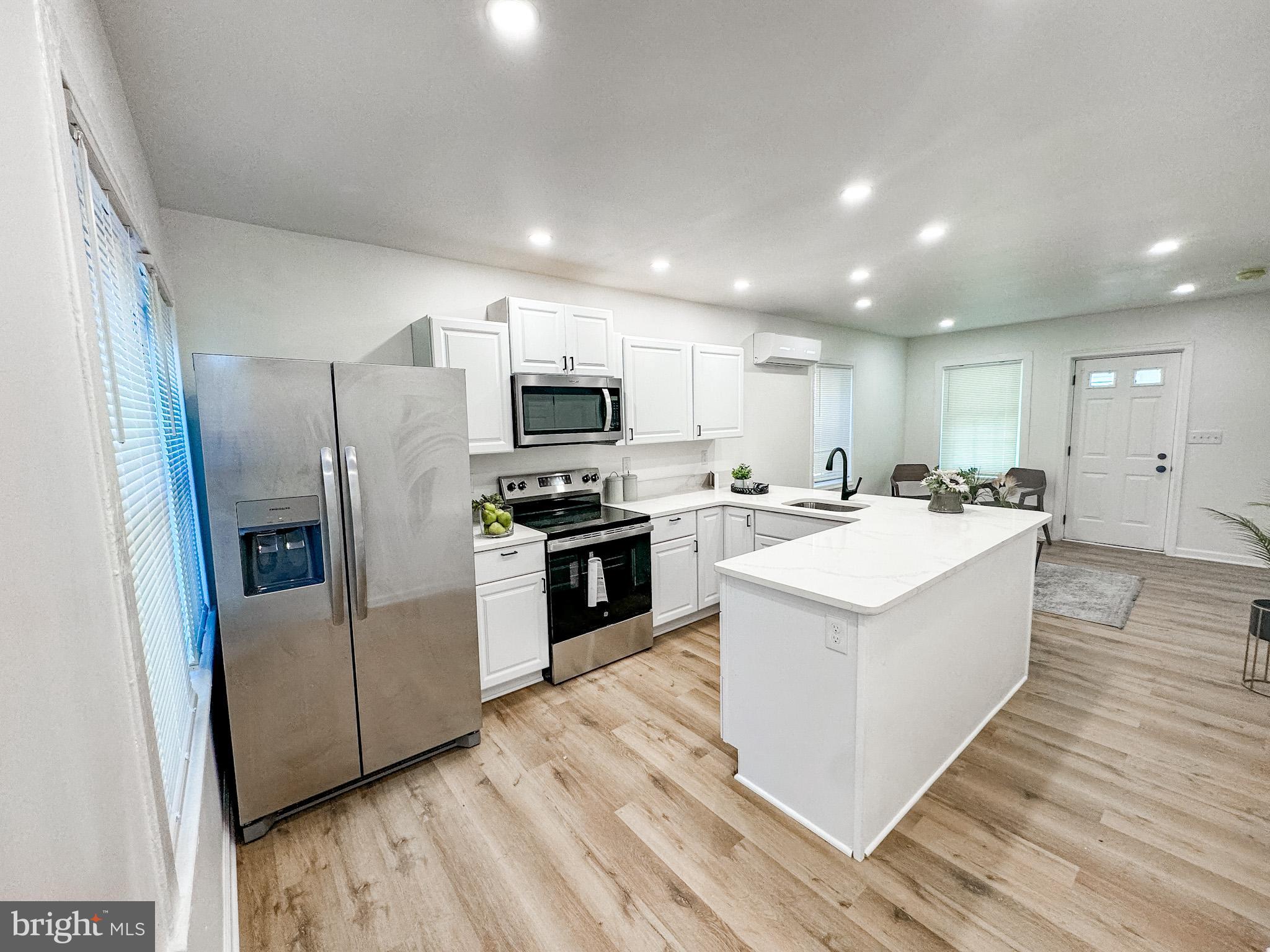 217 Ridge Road Claymont, DE 19703 - Photo 9 of 18 a large kitchen with a center island stainless steel appliances wooden floor and cabinets