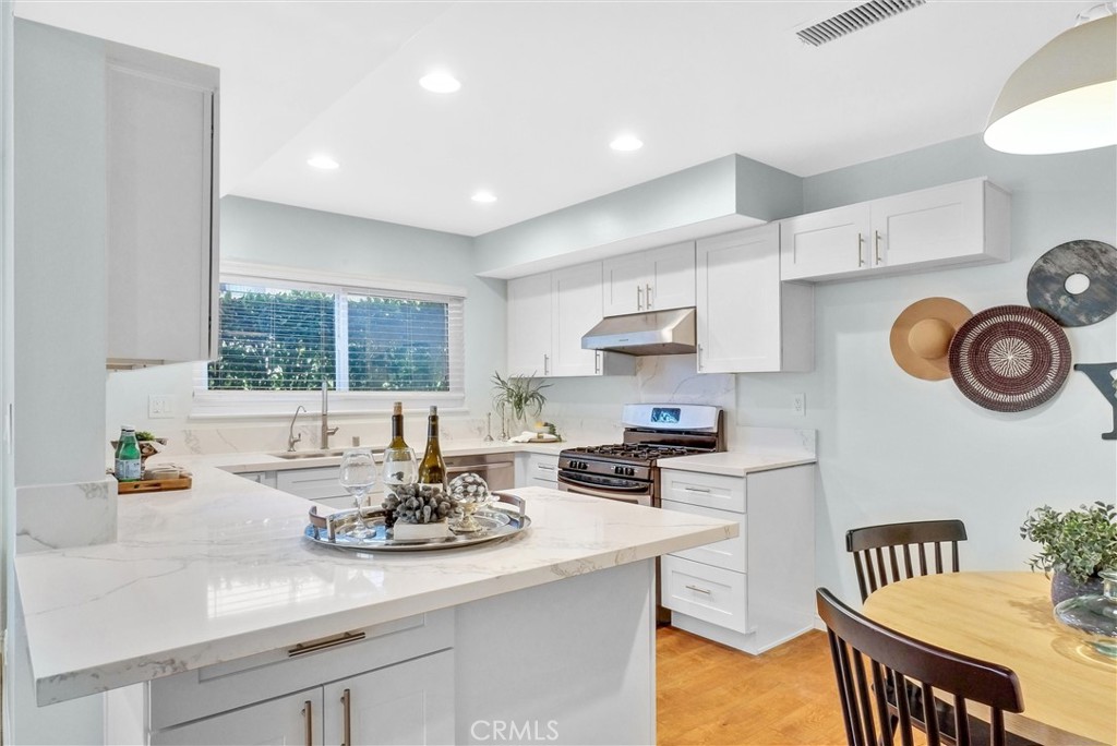 1528 North Gilbert Street Fullerton, CA 92833 - Photo 17 of 40 a kitchen with kitchen island cabinets a sink and a stove