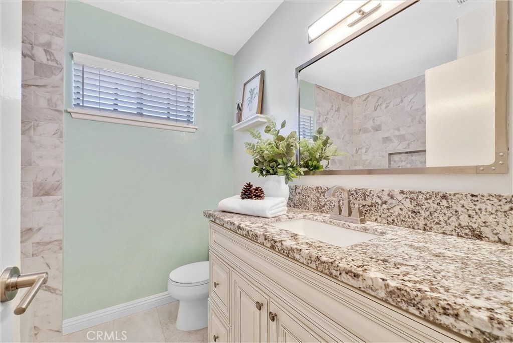 1528 North Gilbert Street Fullerton, CA 92833 - Photo 25 of 40 a bathroom with a granite countertop sink a toilet and mirror