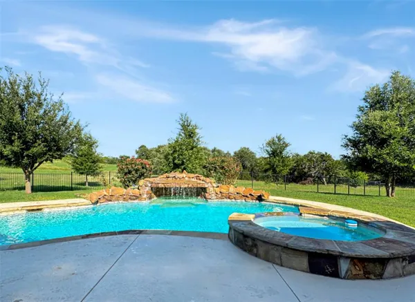 a view of a swimming pool with lawn chairs under an umbrella