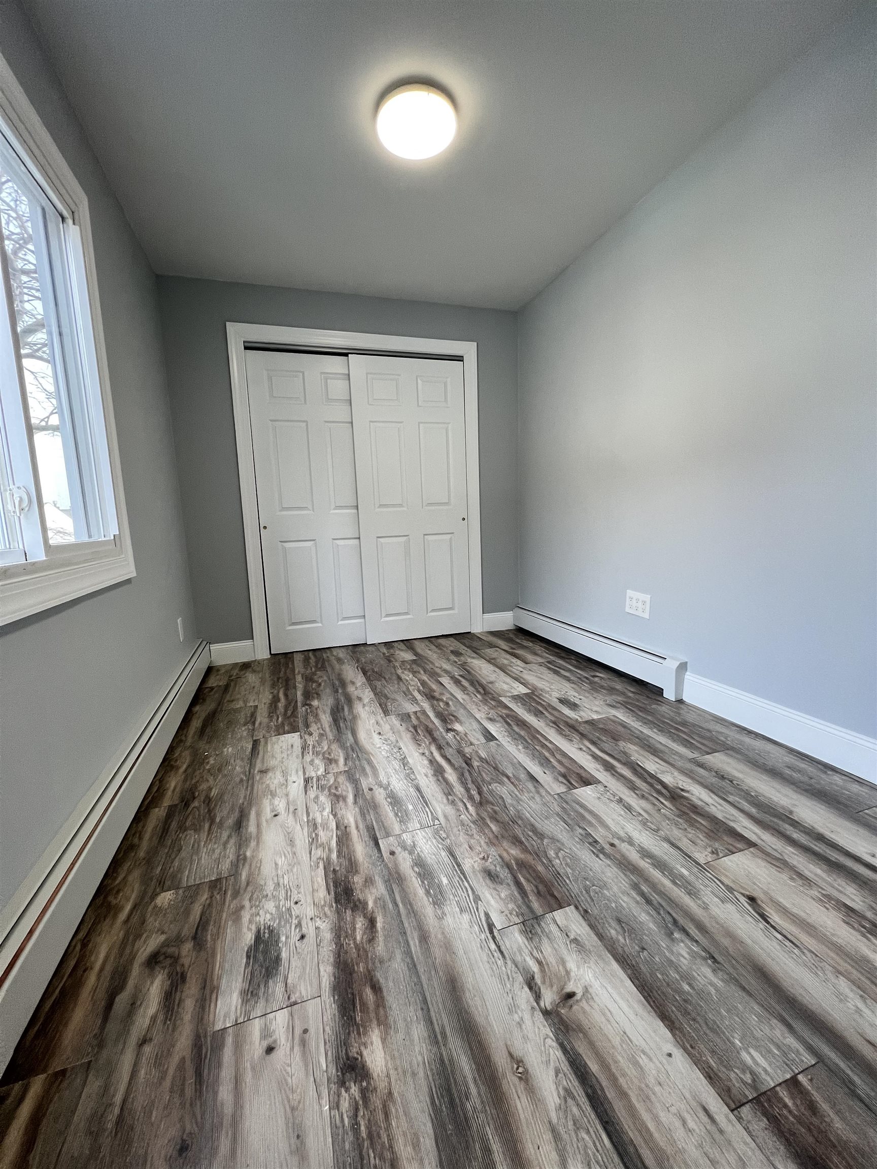 326 70th Street Guttenberg, NJ 07093 - Photo 11 of 15 an empty room with wooden floor and windows