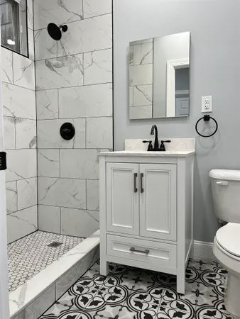 a bathroom with a sink a toilet and shower