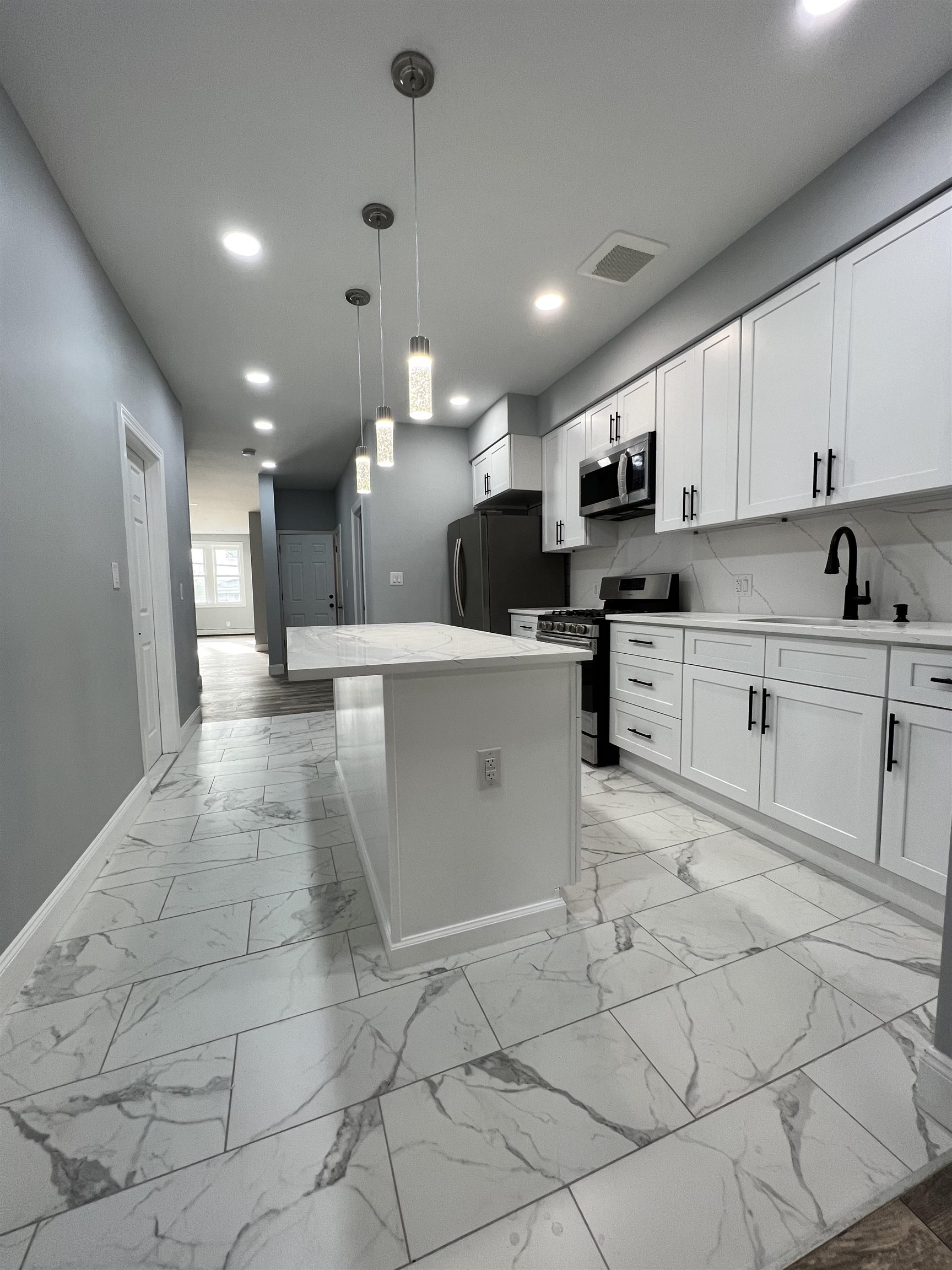 326 70th Street Guttenberg, NJ 07093 - Photo 6 of 15 a kitchen with stainless steel appliances kitchen island granite countertop a sink and cabinets