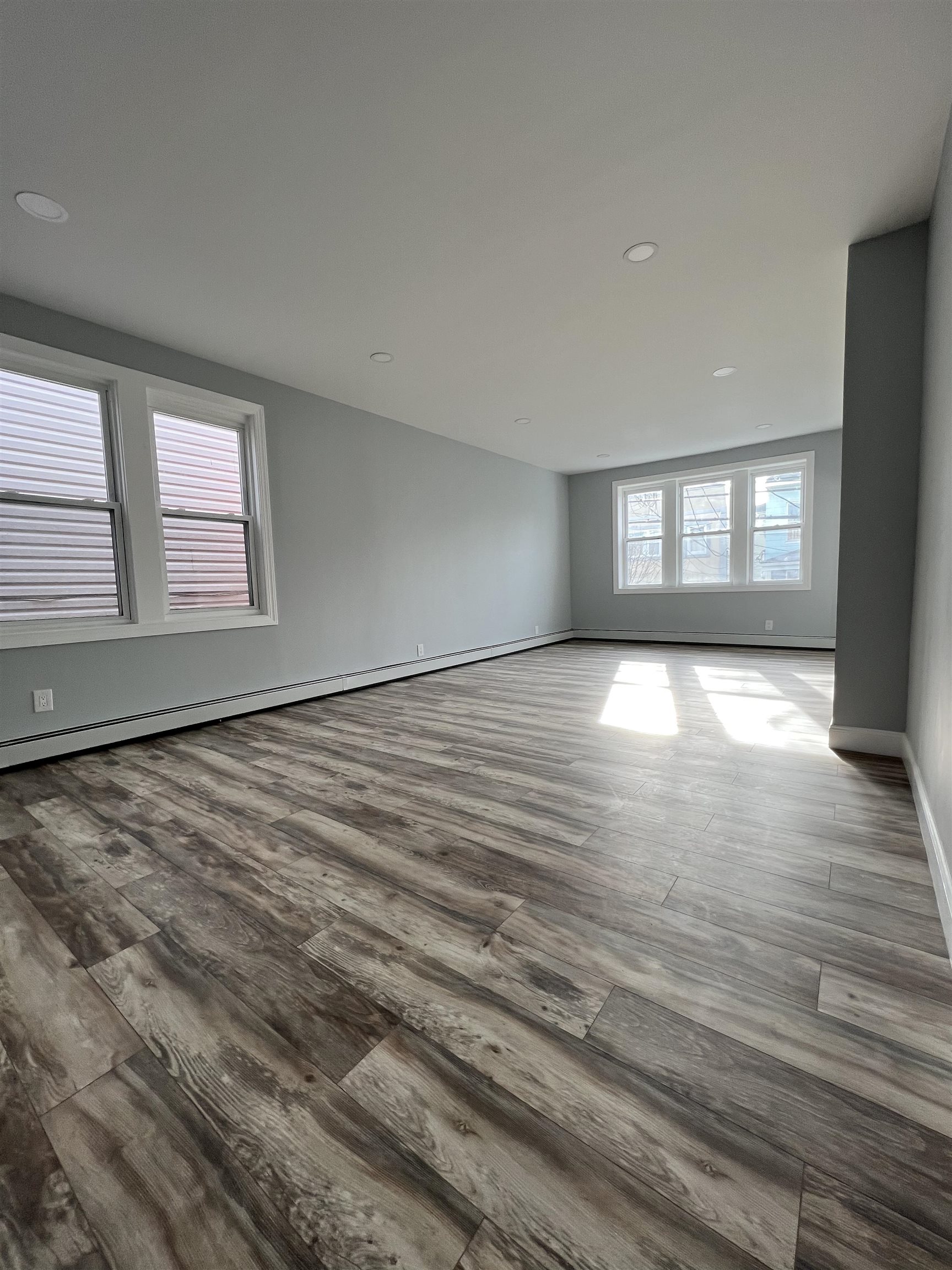 326 70th Street Guttenberg, NJ 07093 - Photo 8 of 15 an empty room with wooden floor and windows