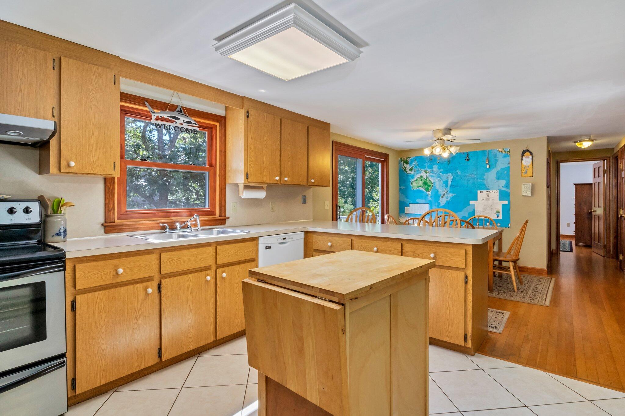 15 Chipmunk Lane Eastham, MA 02642 - Photo 11 of 32 a kitchen with stainless steel appliances granite countertop a stove a sink dishwasher and a refrigerator with wooden floor
