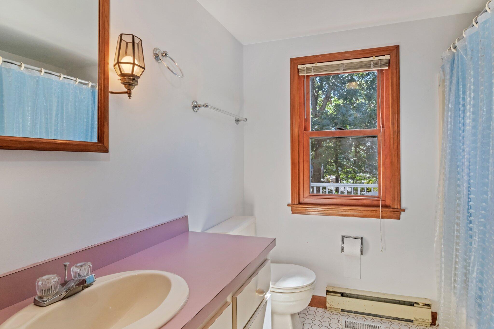 15 Chipmunk Lane Eastham, MA 02642 - Photo 15 of 32 a bathroom with a granite countertop toilet a sink a mirror and a window
