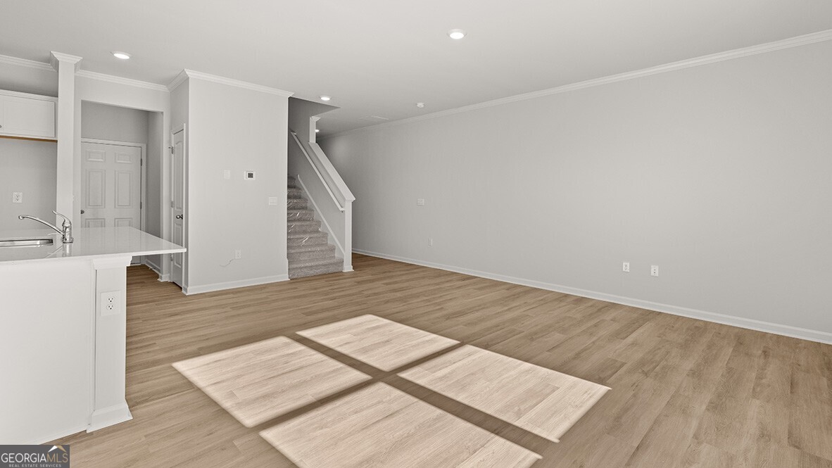 3253 Ryker Road, Unit 304 Gainesville, GA 30507 - Photo 11 of 32 a view of an empty room with wooden floor and a kitchen