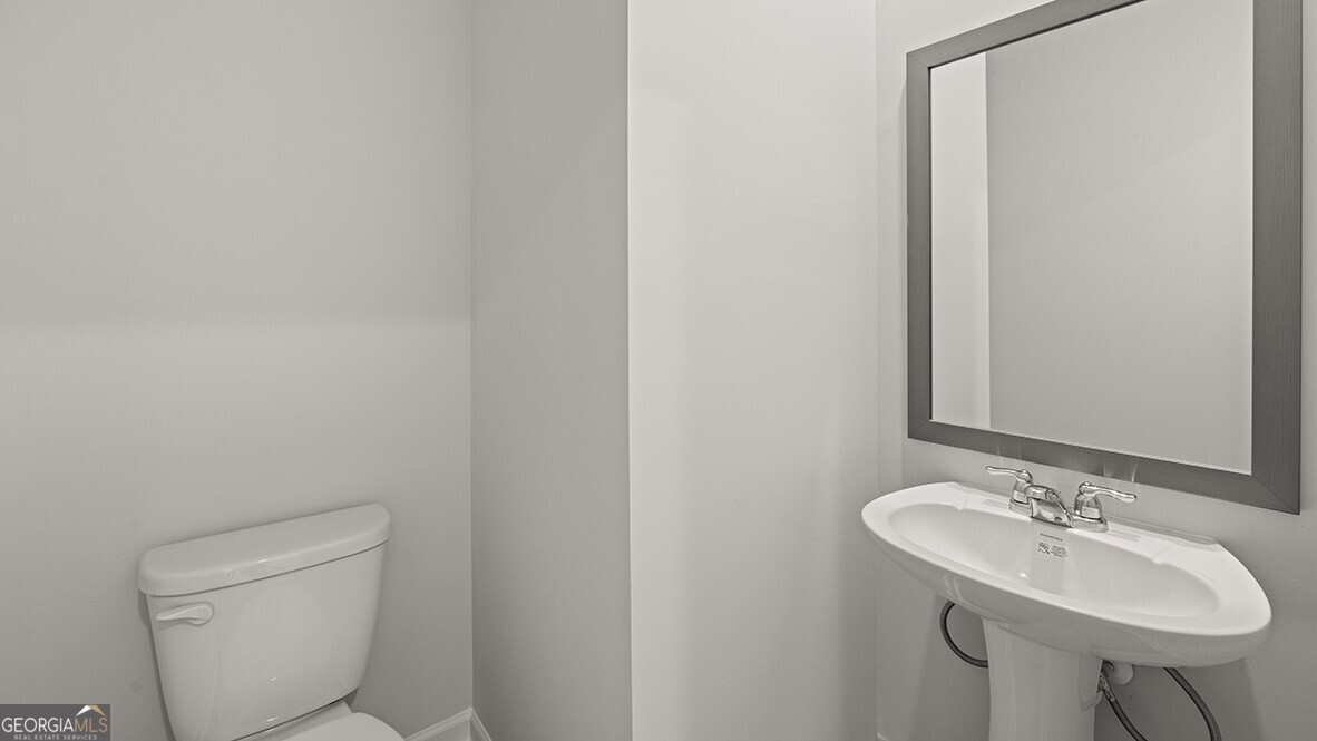 3253 Ryker Road, Unit 304 Gainesville, GA 30507 - Photo 13 of 32 a bathroom with a toilet sink and mirror