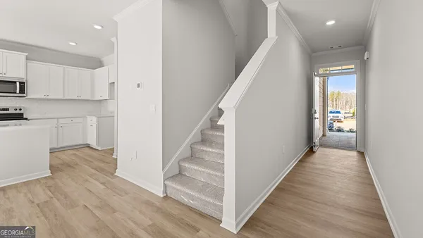 a view of a hallway with wooden floor and staircase
