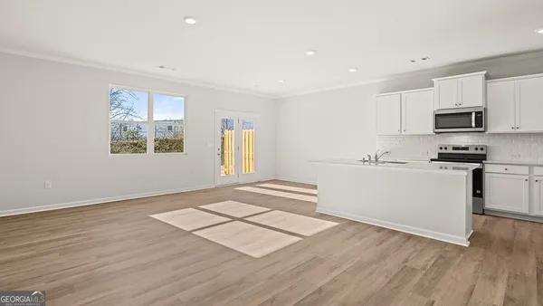 a view of kitchen with stainless steel appliances granite countertop a stove a sink and a microwave
