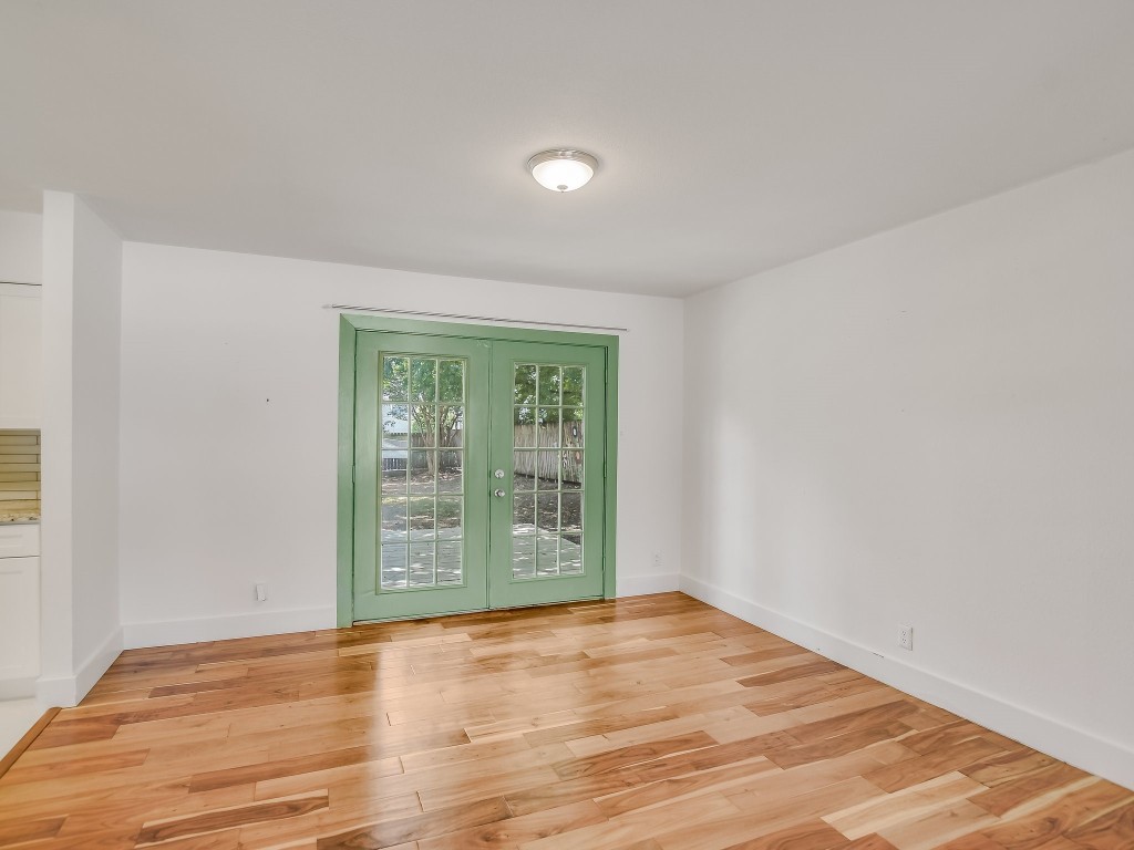 7617 Eastcrest Drive Austin, TX 78752 - Photo 7 of 20 a view of an empty room with wooden floor and a window