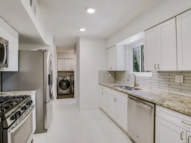 a kitchen with a sink stove and cabinets