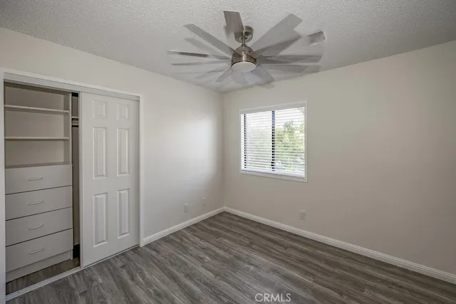 an empty room with a ceiling fan and window