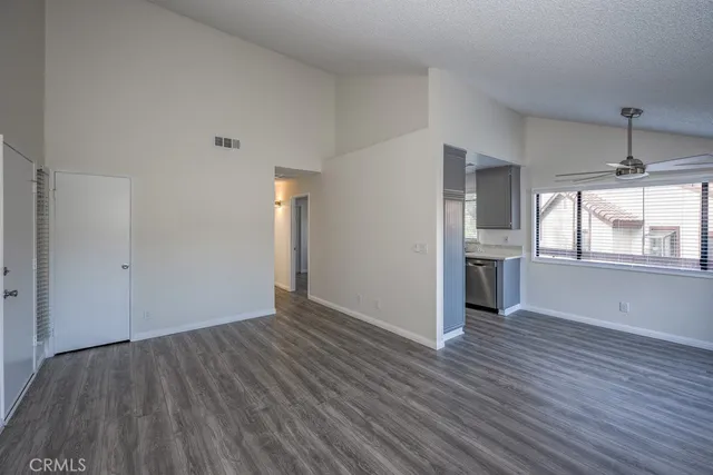 wooden floor in an empty room with a kitchen