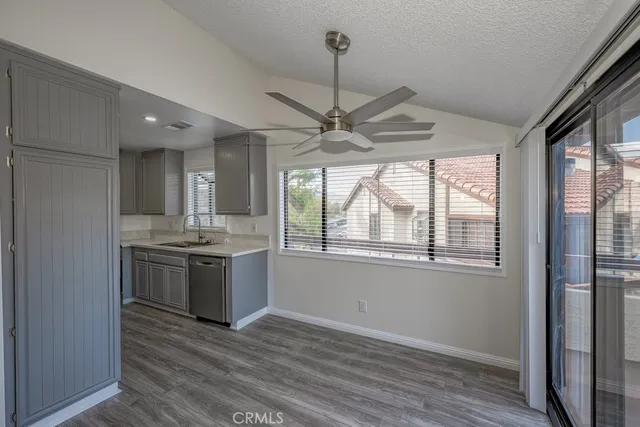 a view of an empty room with a kitchen and wooden floor