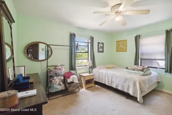 a bedroom with a bed a mirror and window