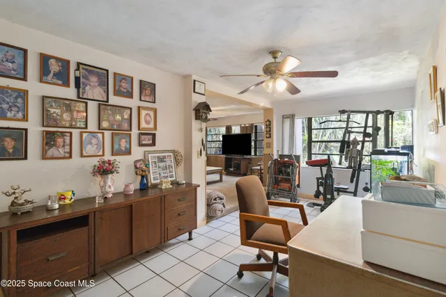 a view of a livingroom with workspace and a window