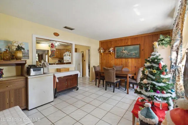 a living room with furniture a dining table and a potted plant
