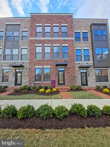 a front view of a building with a yard and plants
