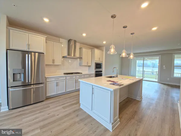 a kitchen with kitchen island a sink stainless steel appliances and refrigerator