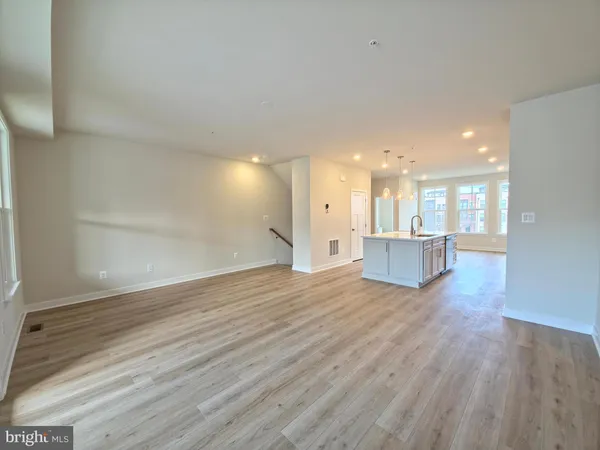 a view of a kitchen with wooden floor and and a window