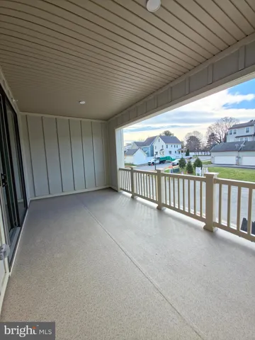 a view of a room with wooden floor and kitchen view