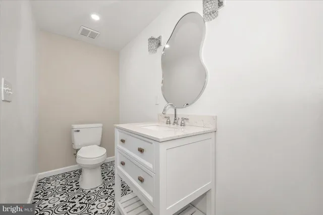 a bathroom with a sink toilet and a mirror
