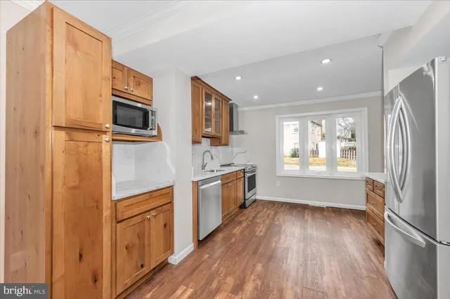 a kitchen with a refrigerator a sink and a stove top oven