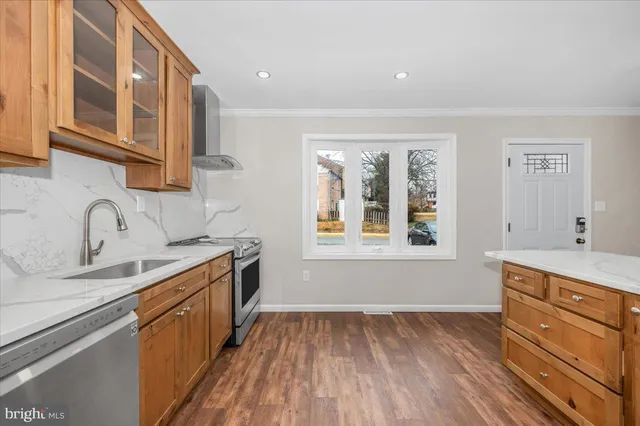 a kitchen with stainless steel appliances granite countertop a sink stove and cabinets