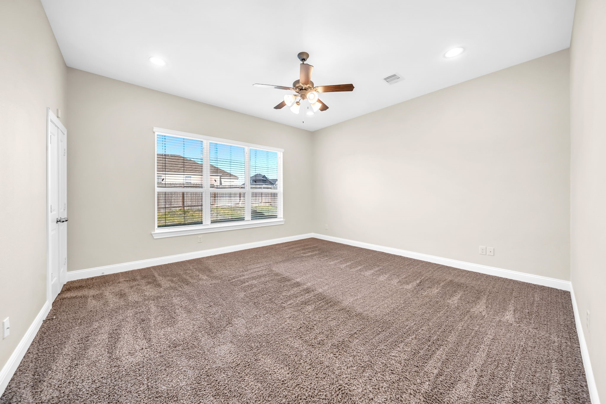 19043 Minero Lane Montgomery, TX 77356 - Photo 12 of 26 Primary bedroom with ceiling fan and large windows with coverings.
