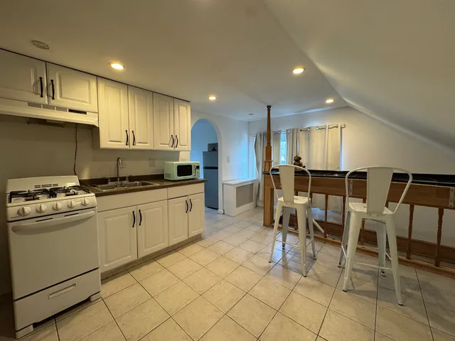 a kitchen with a dining table chairs and cabinets