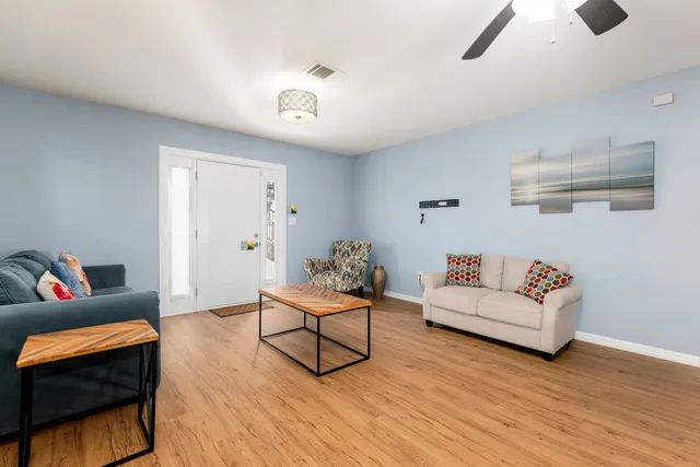 a living room with furniture and a wooden floor