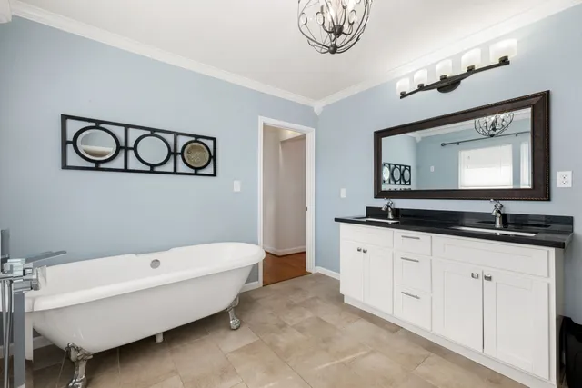 a large bed sitting in a bedroom and a chandelier