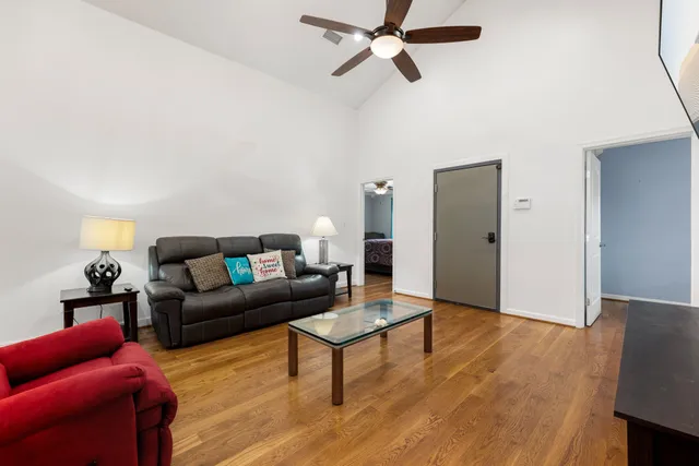 a living room with furniture and a wooden floor