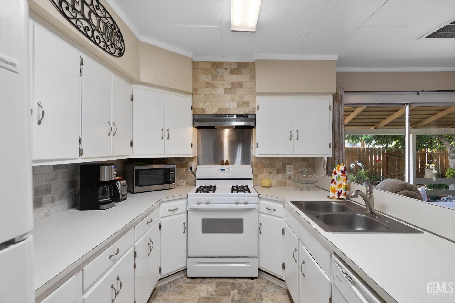 Undisclosed Address Taft, CA 93268 - Photo 23 of 44 a kitchen with white cabinets a sink and appliances