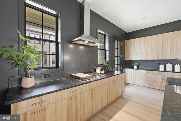 a kitchen with stainless steel appliances granite countertop a sink a stove and a wooden floors