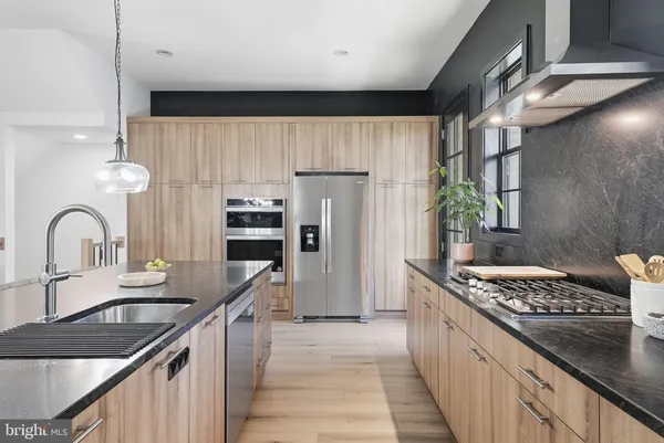 a kitchen with kitchen island granite countertop a sink stove and cabinets