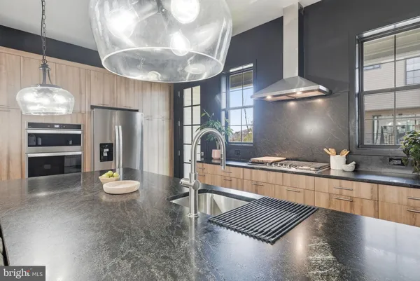 a kitchen with stainless steel appliances granite countertop a sink a stove and a refrigerator
