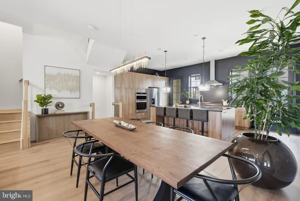 a kitchen with stainless steel appliances granite countertop a sink dishwasher a stove and a refrigerator with wooden floor