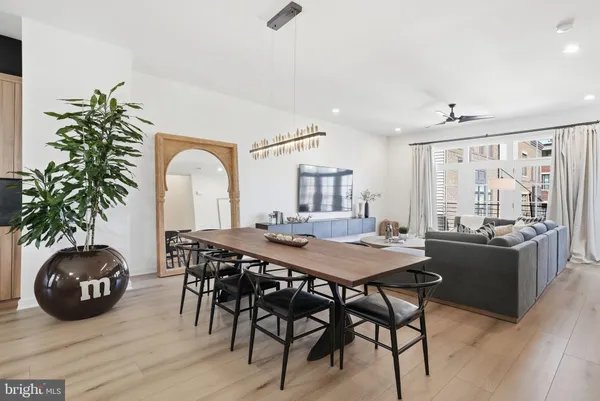 a kitchen with stainless steel appliances kitchen island granite countertop a table chairs and a refrigerator