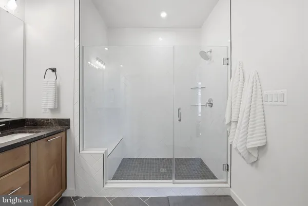 a bathroom with a granite countertop sink a toilet and shower