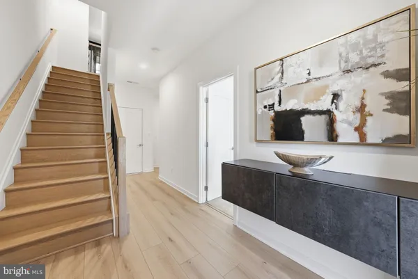 a view of a hallway with wooden floor and staircase