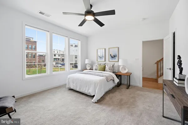 a spacious bedroom with a bed chandelier and a window