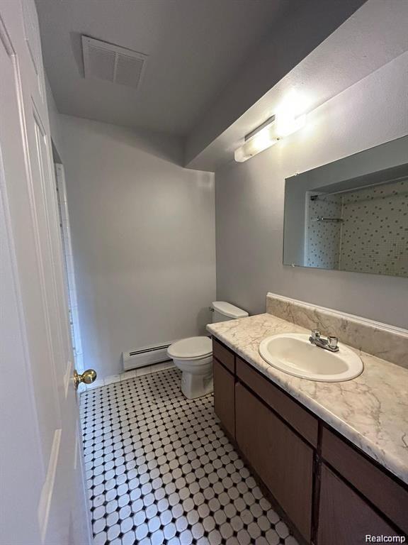 16480 East 9 Mile Road, Unit 102 Eastpointe, MI 48021 - Photo 9 of 13 Vanity with an integrated sink and light-colored countertop, dark wood-finish cabinetry, and black and white patterned floor tiles