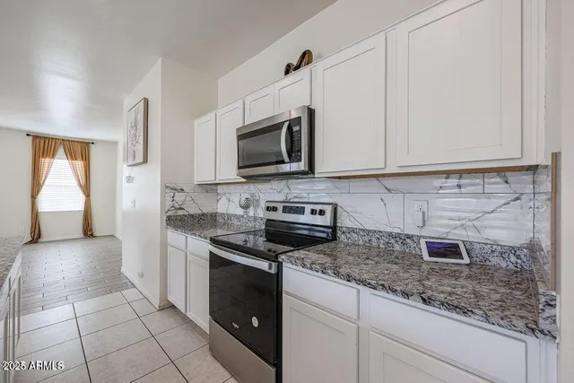 a kitchen with stainless steel appliances granite countertop a stove a sink and a microwave