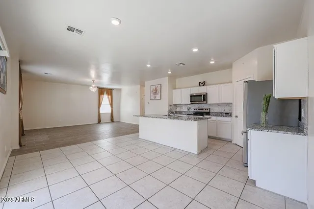 a kitchen with a refrigerator and a stove top oven