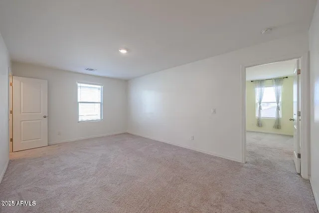 an empty room with windows and closet