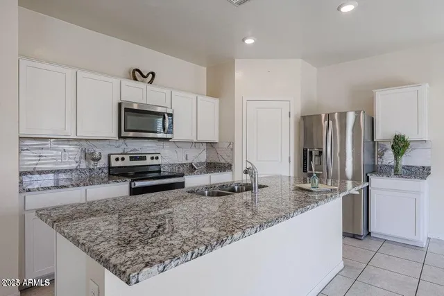 a kitchen with stainless steel appliances granite countertop a sink stove and refrigerator