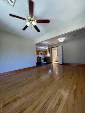 a view of empty room with wooden floor