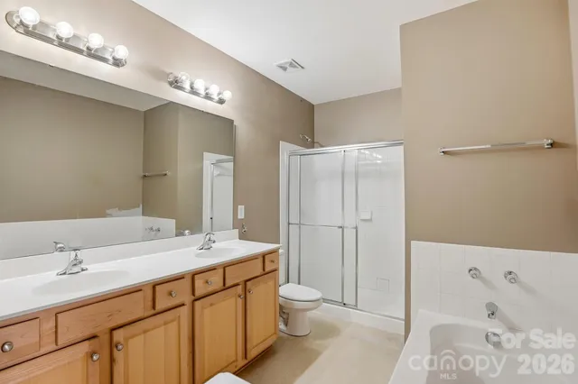 an empty room with windows and ceiling fan